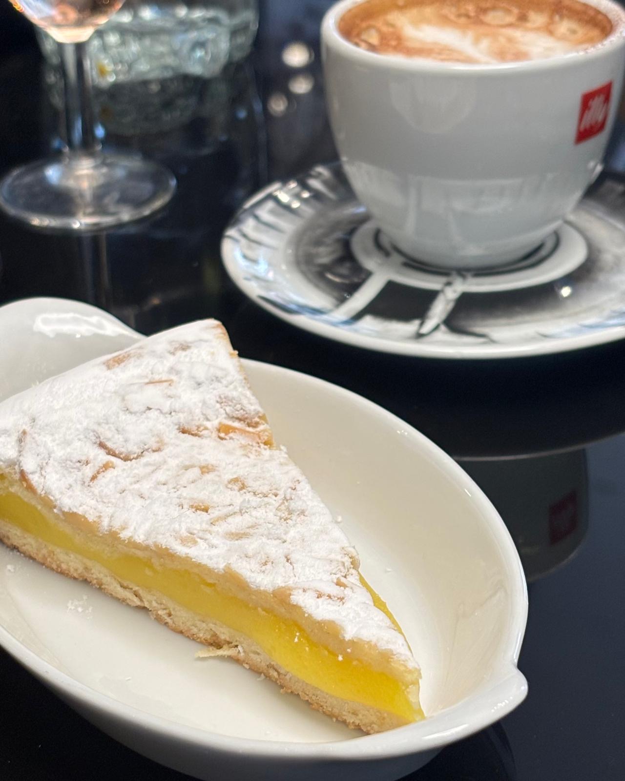 Photo montrant un dessert typiquement italien servi au Caffe Corto - Une Tarte de la Nonna - Pâte brisée, crème parfumée au citron, pignons de pin et amandes, saupoudrée de sucre glace.jpg